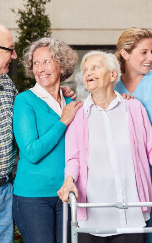 Fröhliche Senioren und eine Pflegekraft