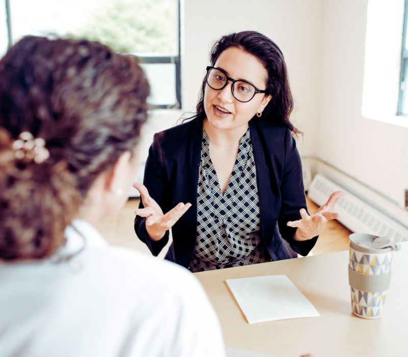Eine Frau vom Pflegedienst berät Angehörige einer pflegebedürftigen Person