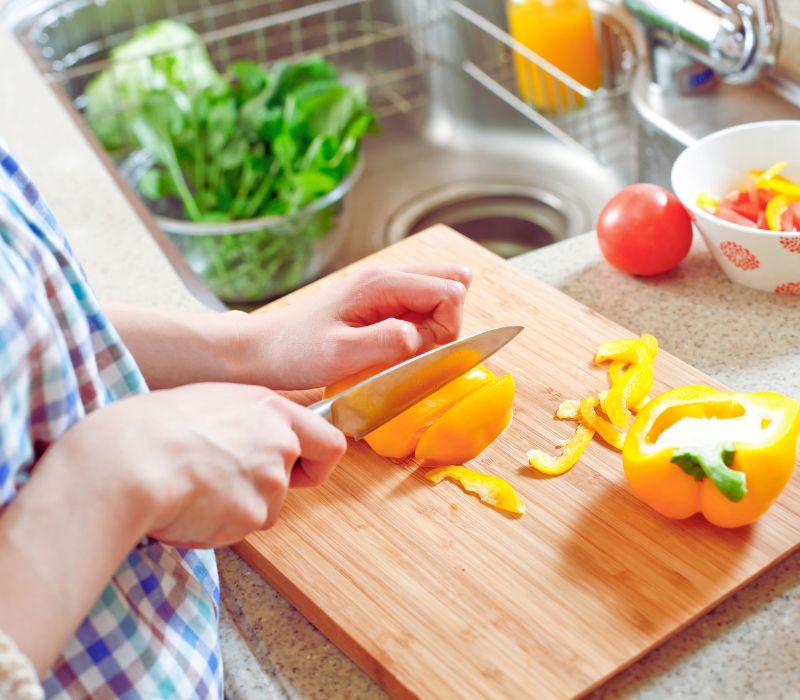 eine Pflegekraft  schneidet Gemüse in der Küche